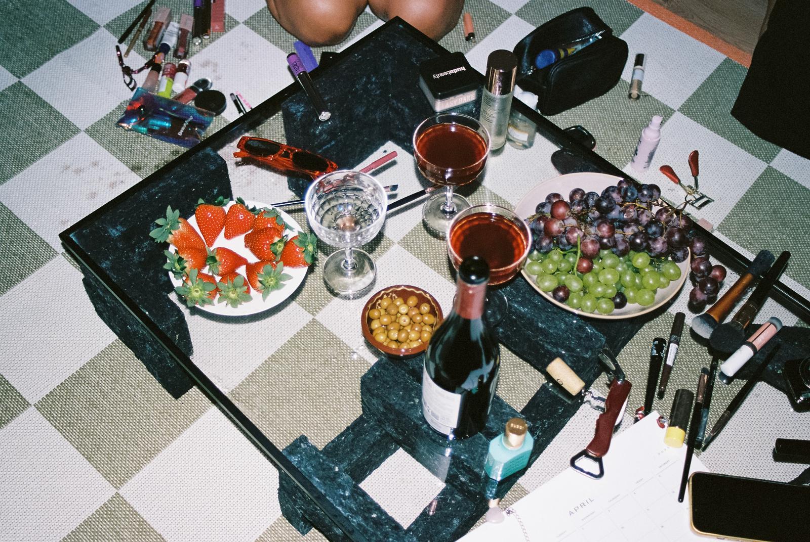 Messy table with wine glasses, lipstick, and snacks – aftermath of girls night out